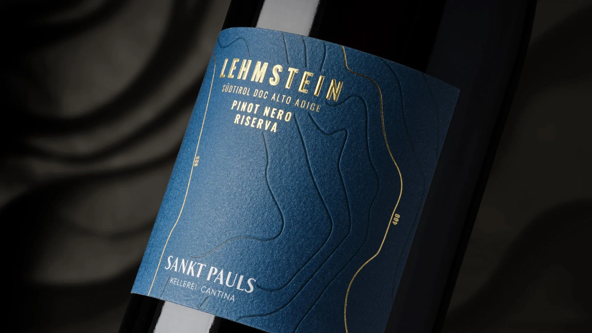 Etichetta Lehmstein Pinot Nero Riserva di Sankt Pauls: carta blu con rilievi e lamina oro