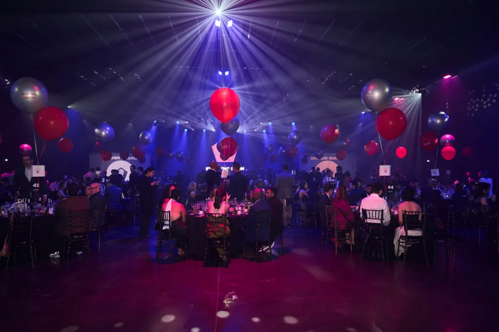The hall during the evening, with tables and red and silver balloons