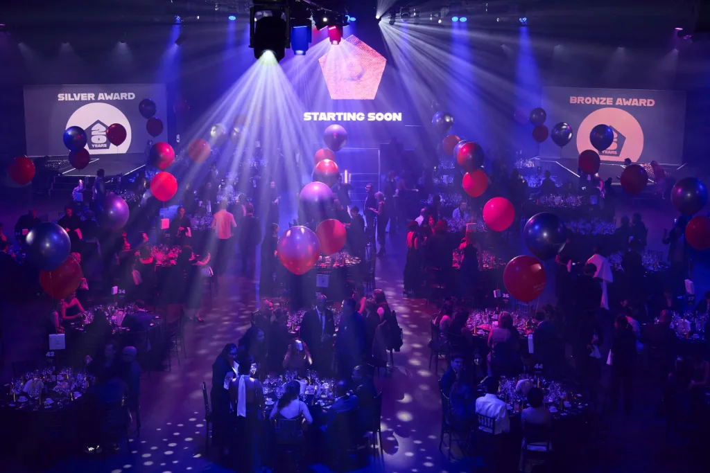 La sala dei Pentawards 2026 vista dall’alto prima della cerimonia, con tavoli, palloncini e luci viola